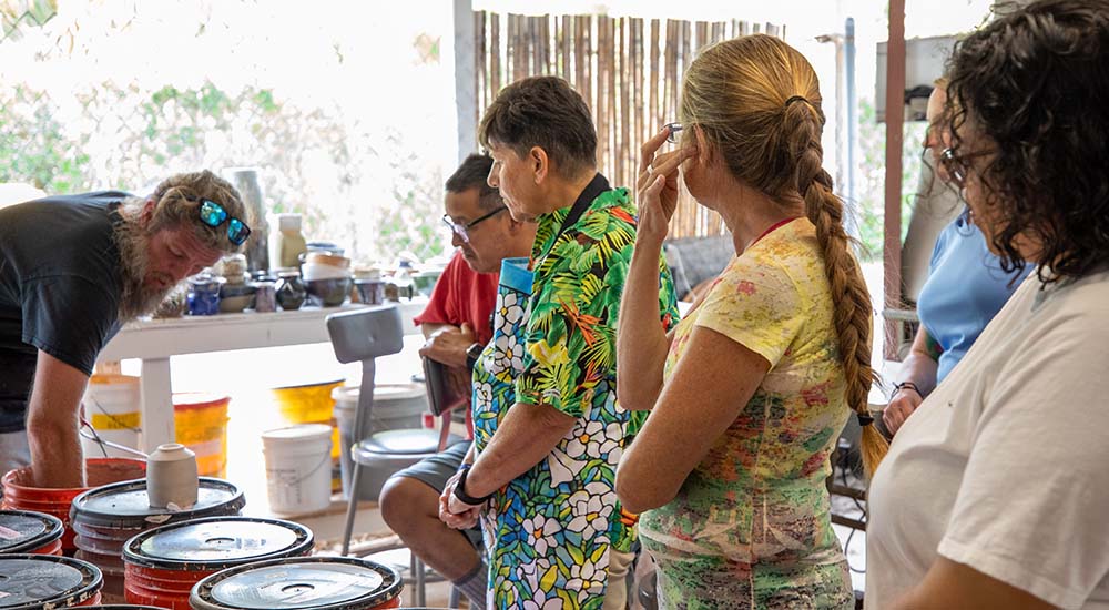 Veterans watch as clay sculptor prepares materials; art therapy