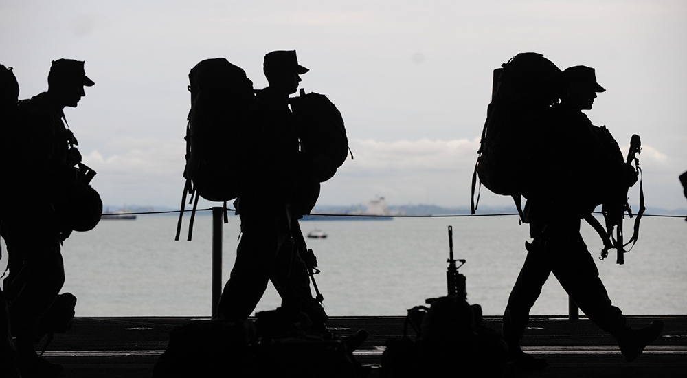 Silhouette photo of three Soldiers with duffle bags; M2VA