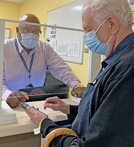 VA staff assisting Veteran with smartphone check-in