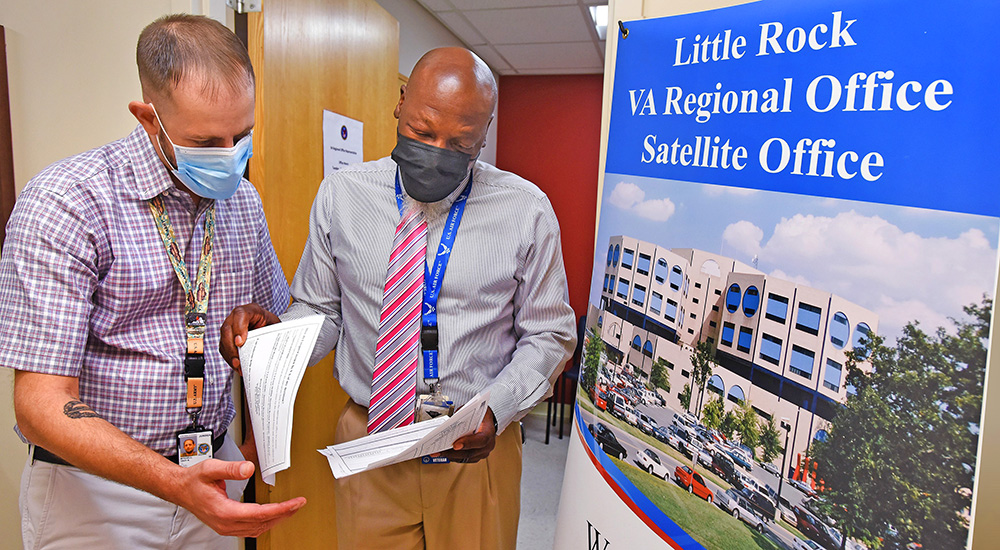 VA staff member assists Veteran with forms; satellite office
