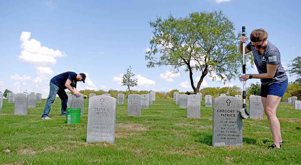 Man and woman cleaning headstones on National Day of Service