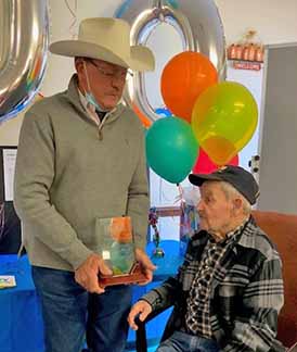 Man presents award to elderly Veteran