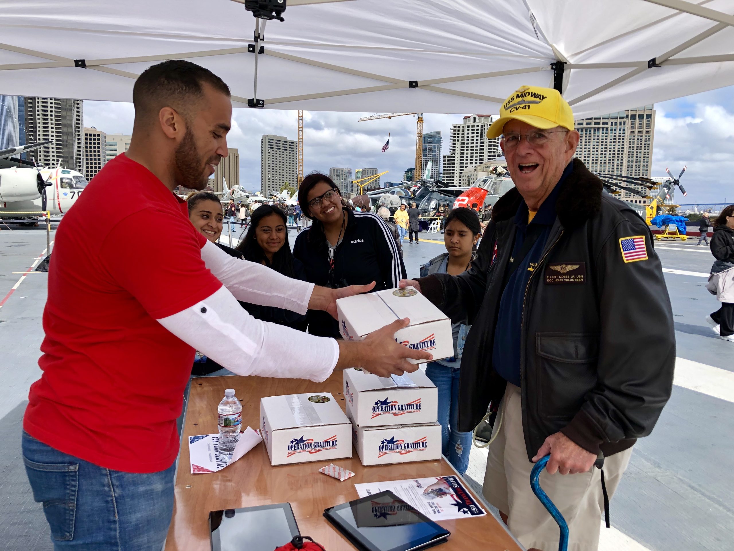 Navy Veteran Elliott Moses Jr. (right) receives an Operation Gratitude care package aboard the U.S.S. Midway in San Diego in 2019. Operation Gratitude plans to deliver over 20,000 Care Packages to Veterans in time for Veterans Day.