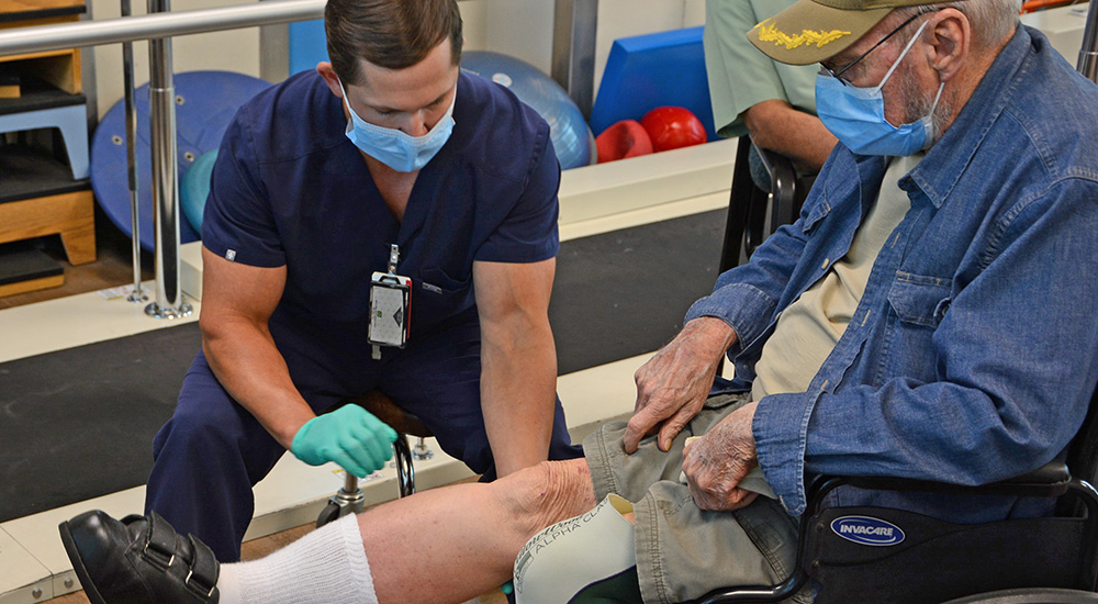 An amputation specialist inspects a Veteran’s leg