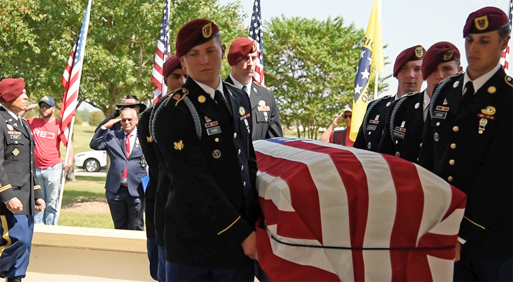 Soldiers carry flag draped coffin of American WWII Veteran