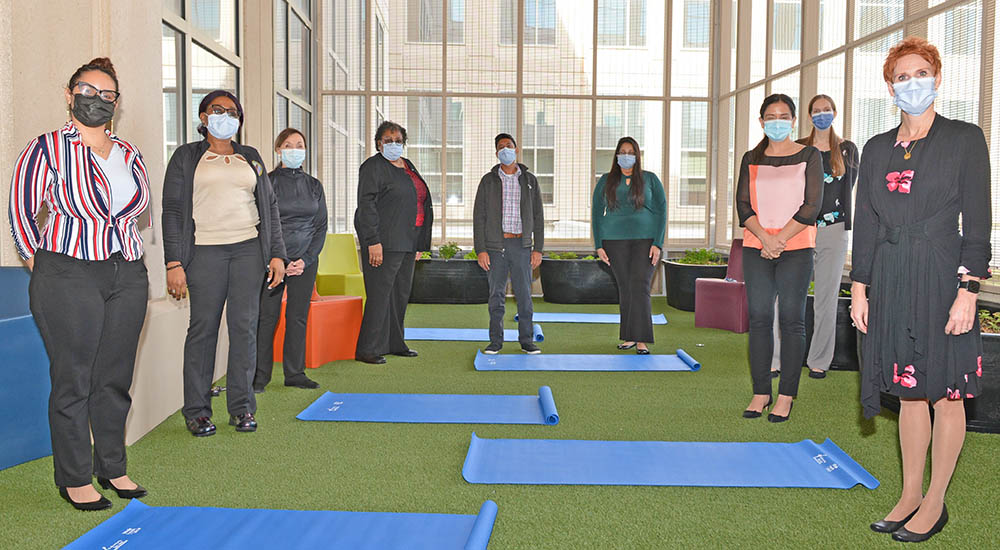 Group of people standing in large room; tranquility garden