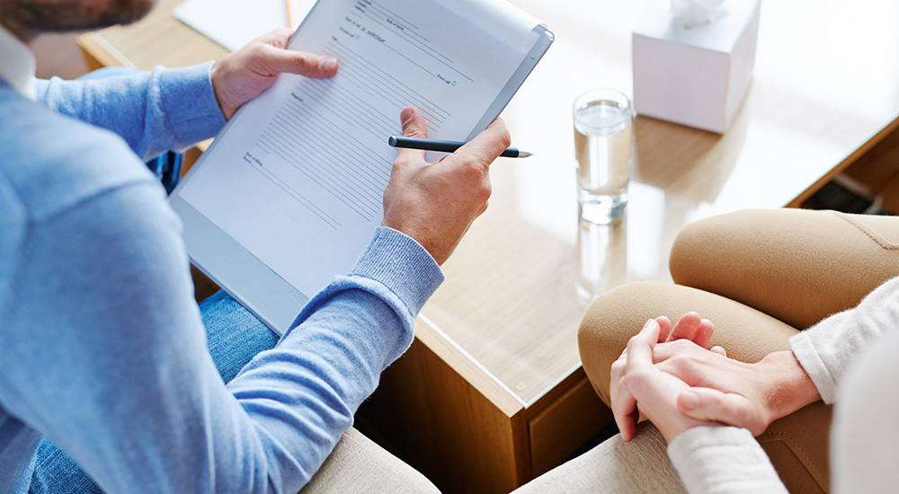 Photo of a male counselor completing an addiction assessment