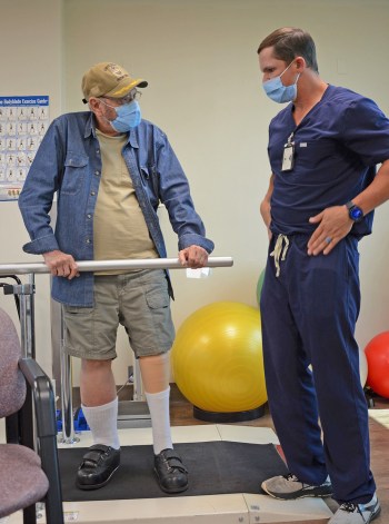 Amputation specialist consults with Veteran at walk test
