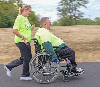Woman pushing man in wheelchair