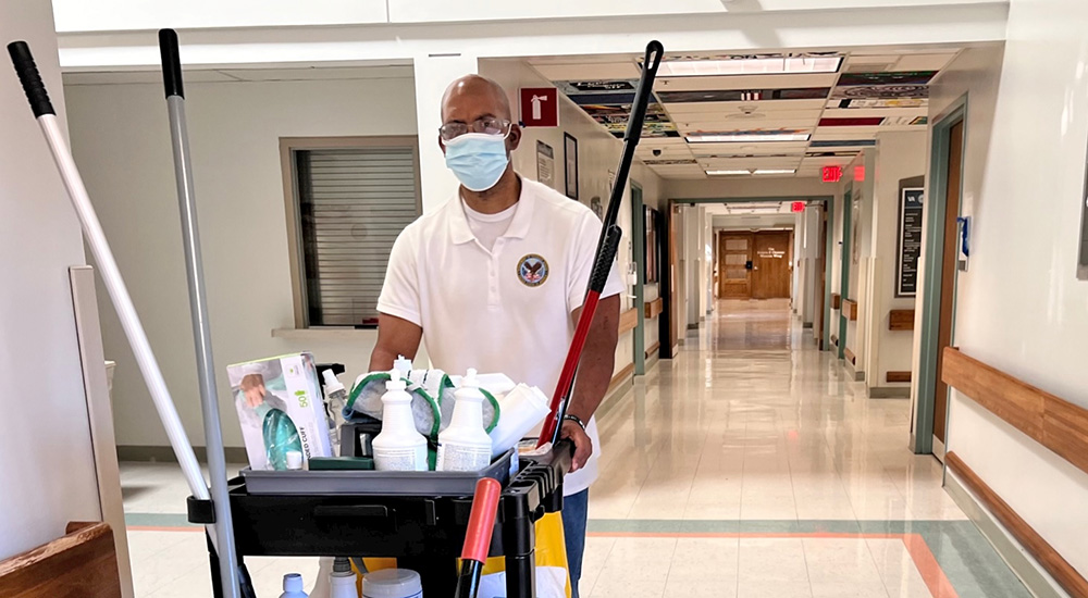 Veteran pushes cart down hospital hallway; Compensated Work Therapy Program