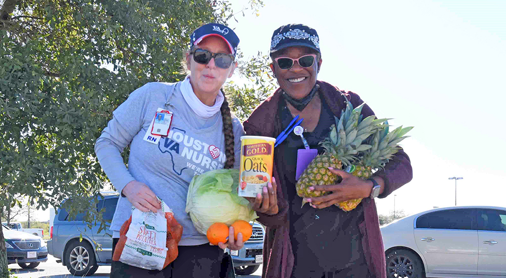 Two VA nurses hold groceries to distribute to Veterans