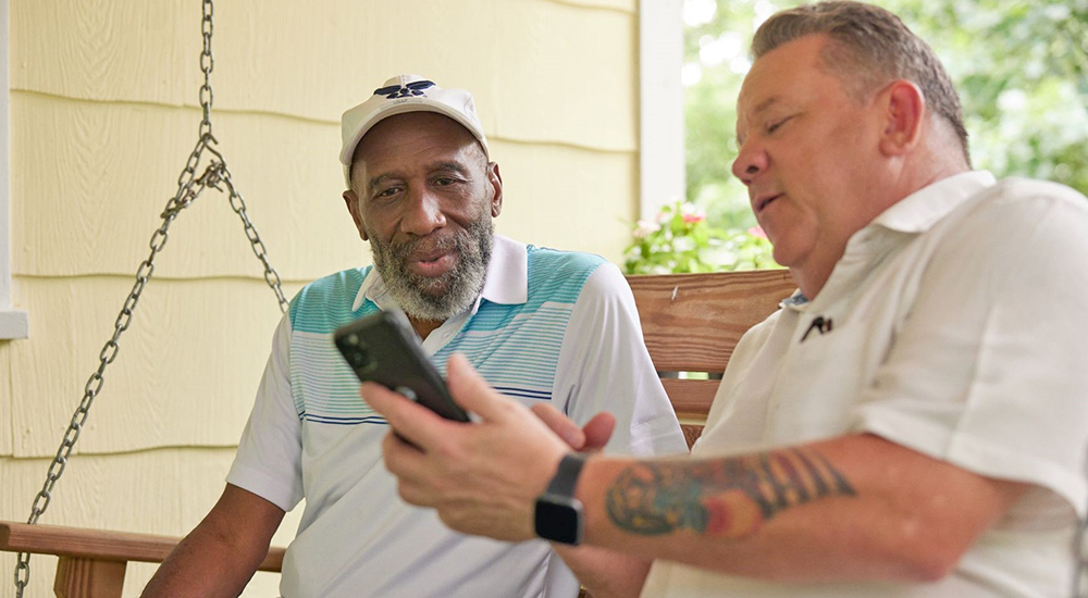 Man demonstrates connecting to internet on phone to Veteran; FCC