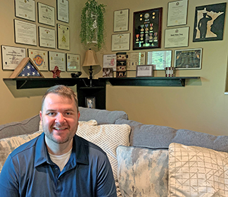 Army Veteran with wall full of awards