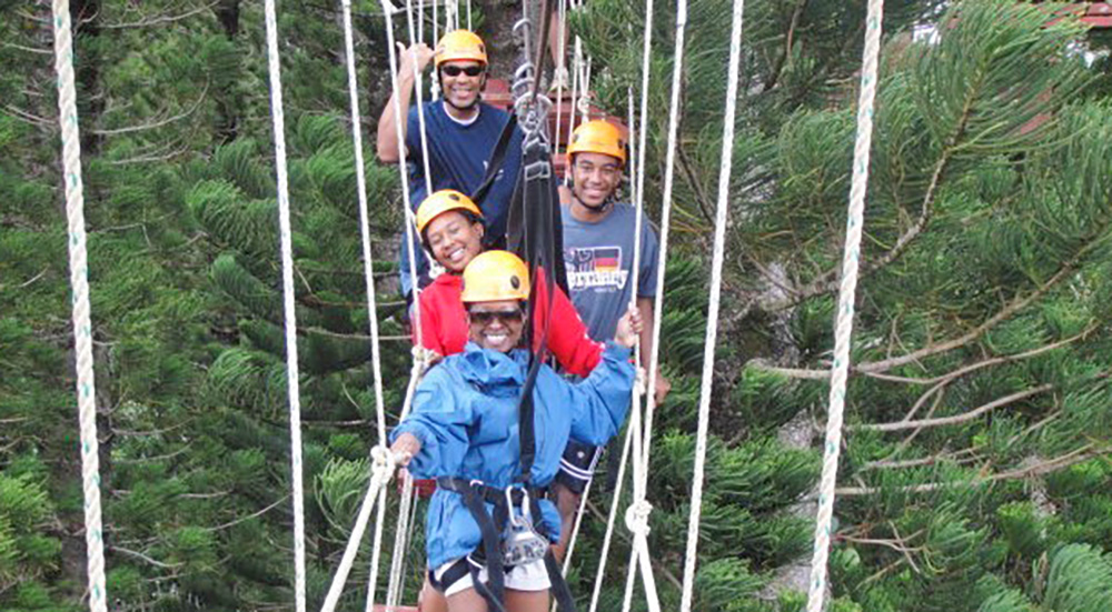 Four people on a rope bridge; traveling