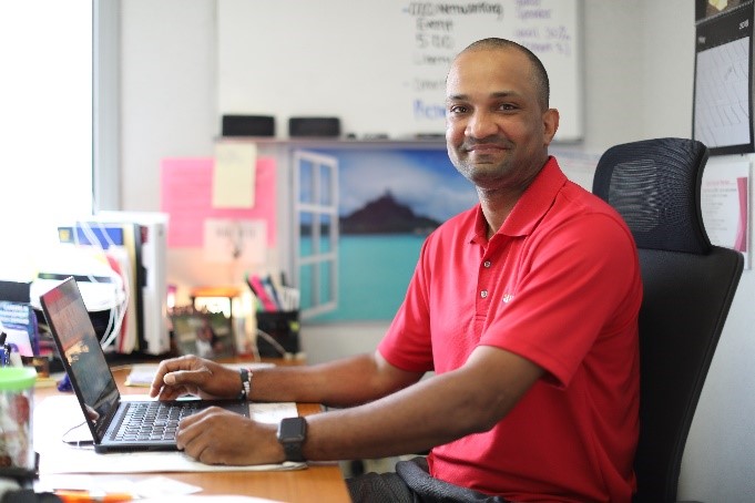 man sitting at computer keyboard smiling