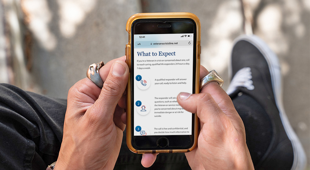Image of hands holding a cell phone; Veterans Crisis Line