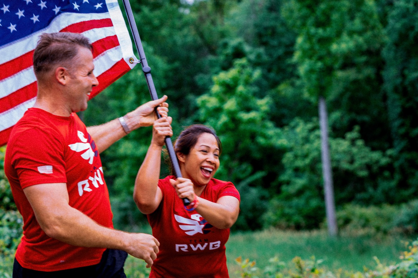 woman and man running with american flag representing team rwb
