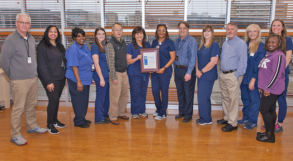 Thirteen Jackson VA employees with framed award