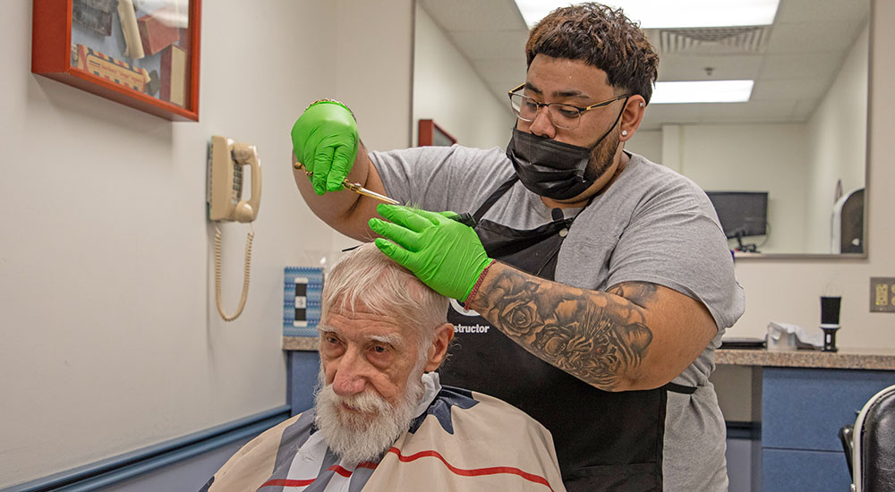 Barber giving senior Veteran haircut; haircuts