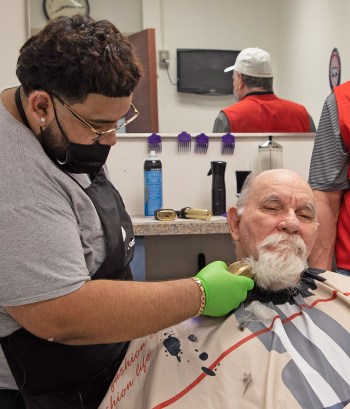 Barber trimming senior Veteran’s beard