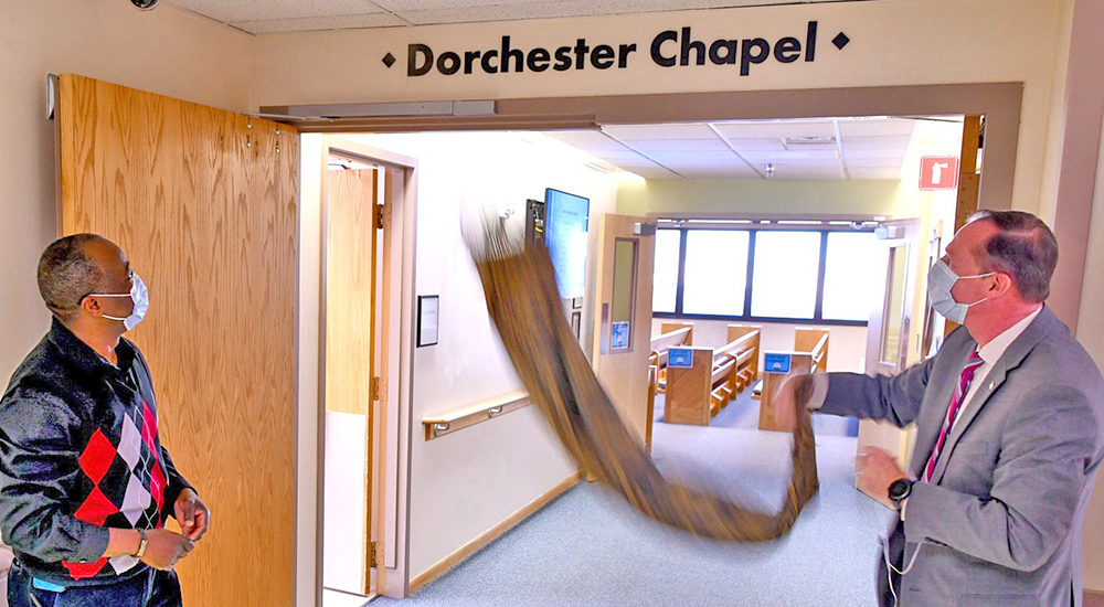 Man pulls down covering from Dorchester Chapel sign