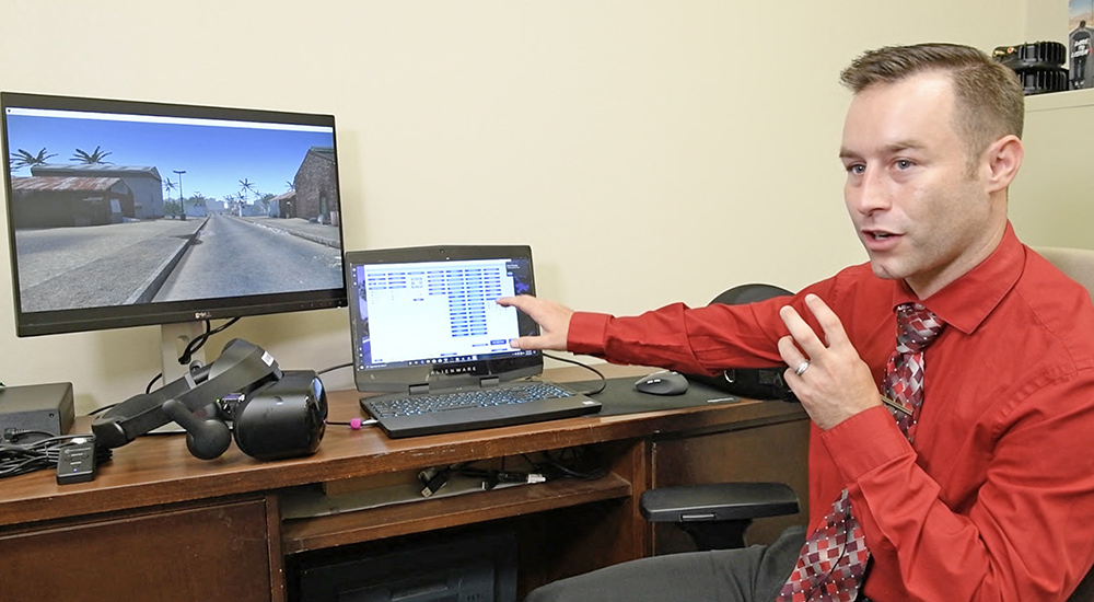 Doctor gesturing toward computer monitors; virtual reality