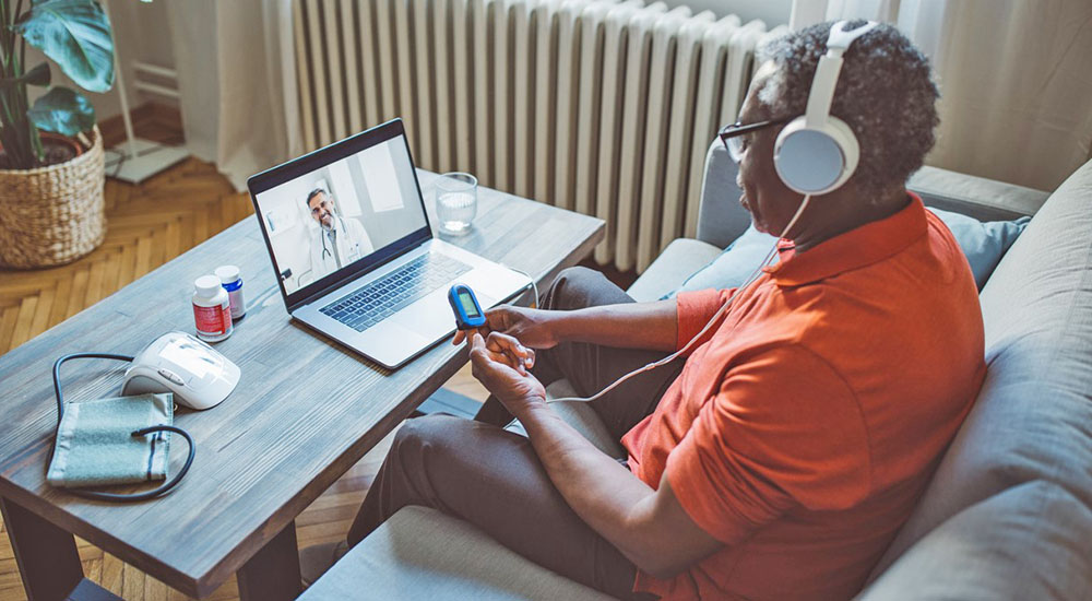 Man looking at computer screen; telehealth