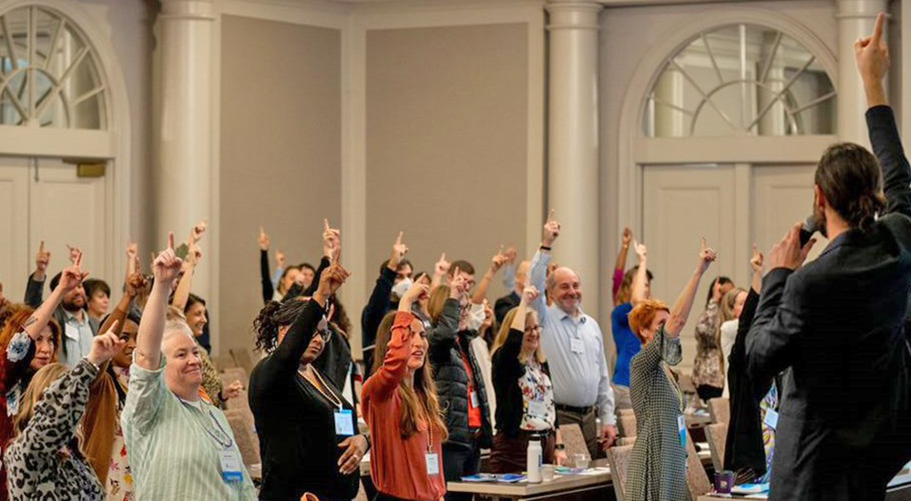 Large group of innovators raising their hands