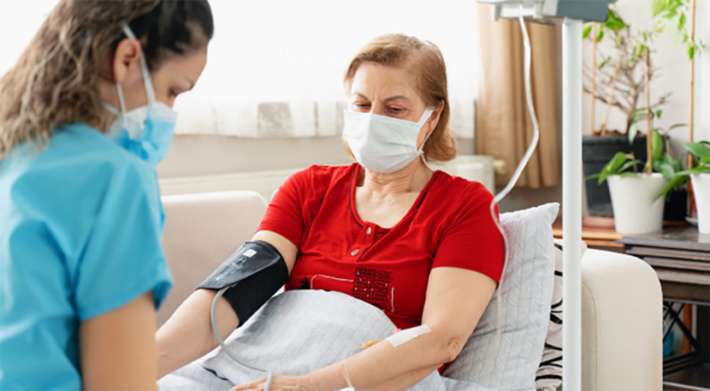 Nurse taking patient’s blood pressure; novel infusion care delivery