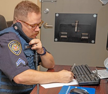 Policeman writing at desk