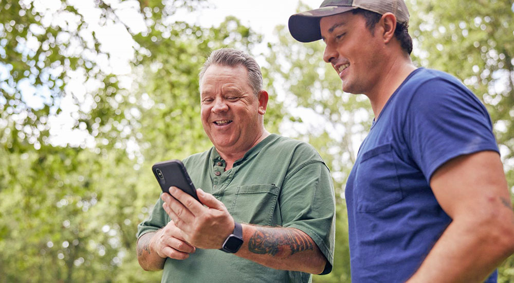 Two men reading phone apps