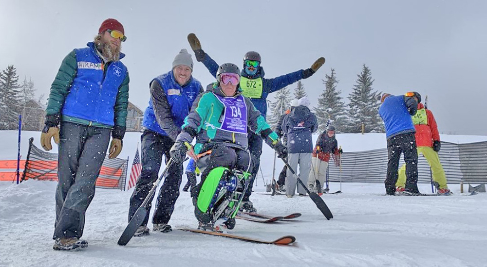 Volunteer bootloaders load a Veteran for skiing