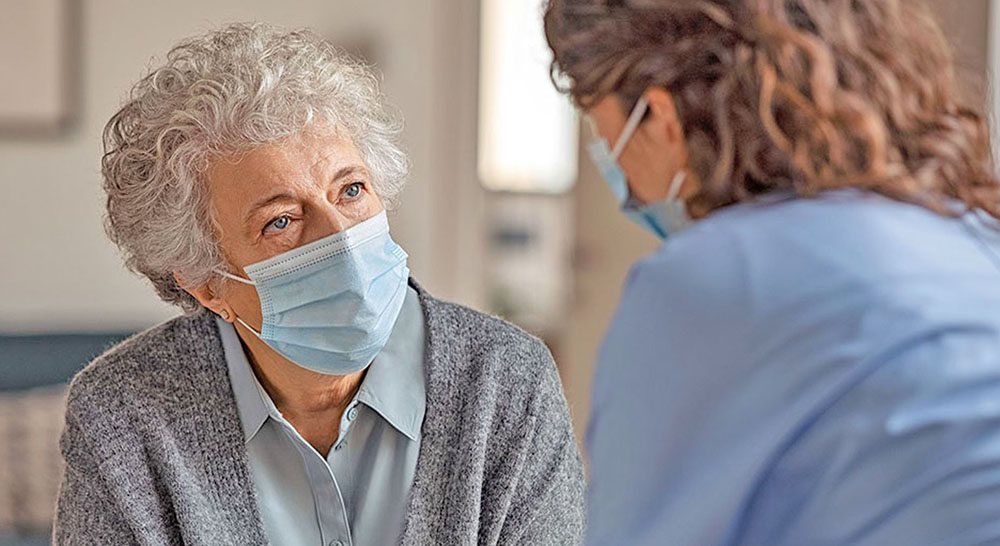 Senior woman in mask with social worker; STRONG Act