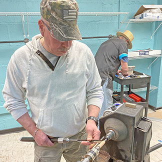 Un veterano con PTSD usa un tornio per girare un pezzo di legno