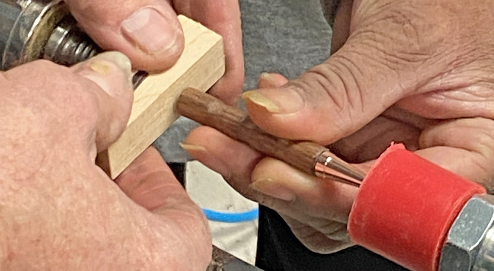 Hands hold a block of wood for Veteran with PTSD; woodcraft