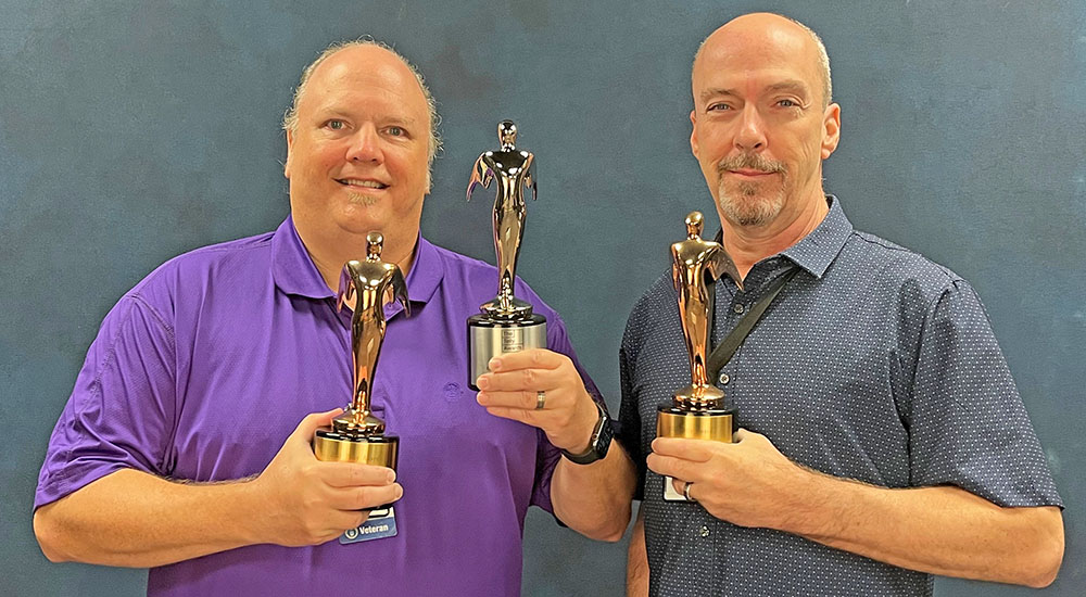 Members of creative team hold global award trophies