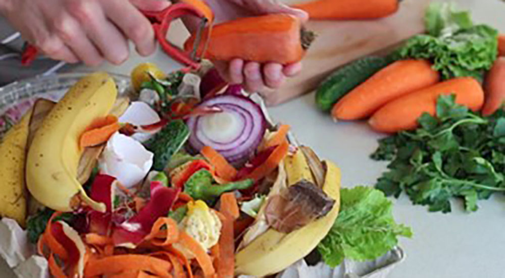 Cook saving food waste for composting