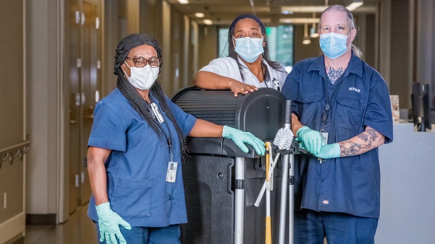 Three environmental service technicians as they patrol the hallways of a VA facility, making sure facilities are clean and tidy.