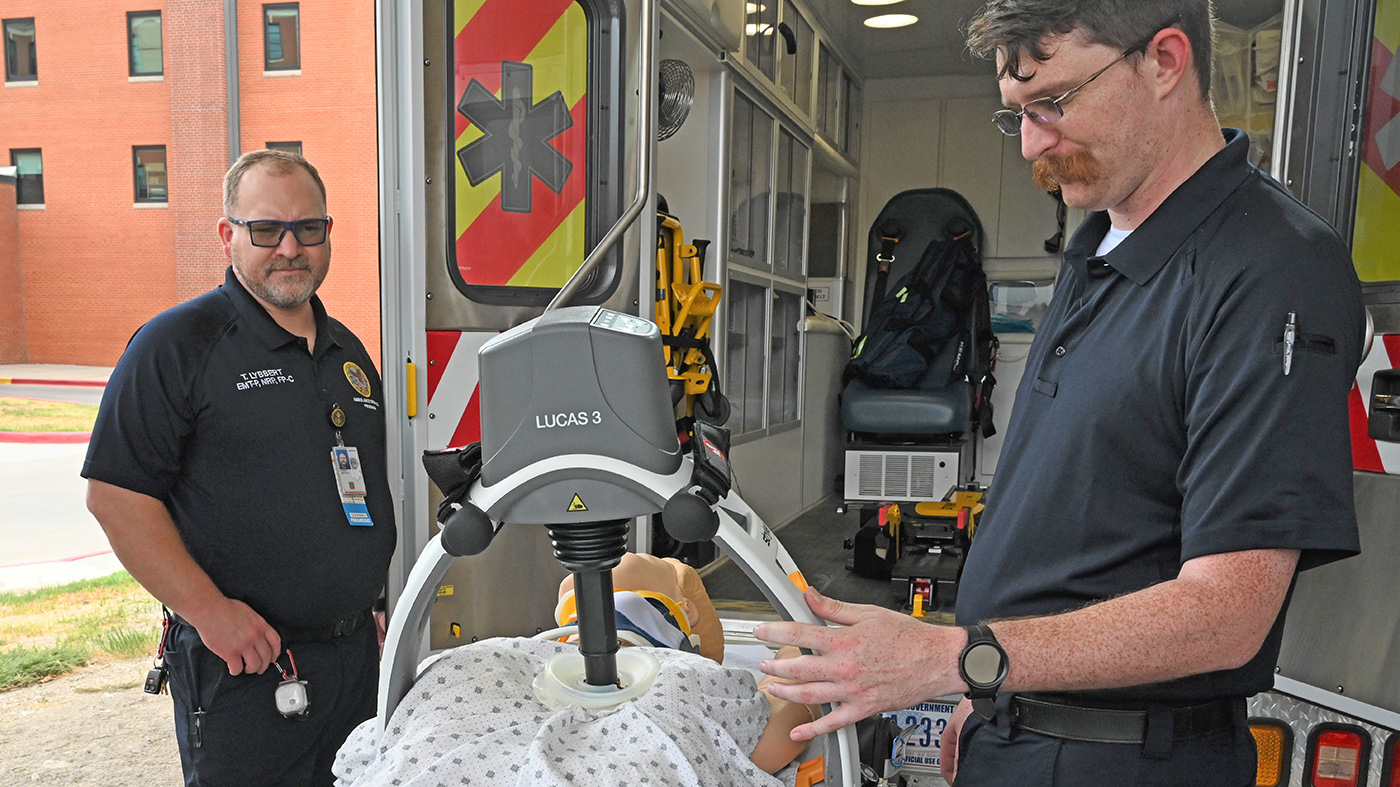 Ambulance transportation team with automated CPR device