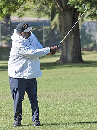 Veteran swings golf club in golf scramble
