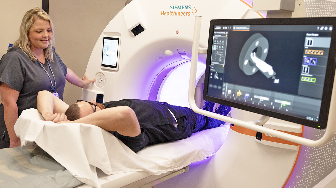 Technician performs procedure with new CT scanner; advanced imaging