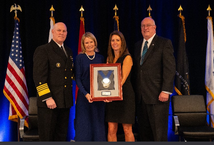 Dream Foundation CEO Kisa Heyer (2nd from left) receives the prestigious 2023 Fisher Service Award in recognition of the foundation's innovate Dreams for Veterans program.