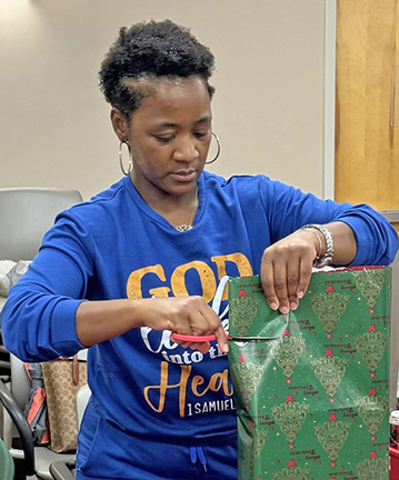 Christmas Shoppe Volunteer wraps present