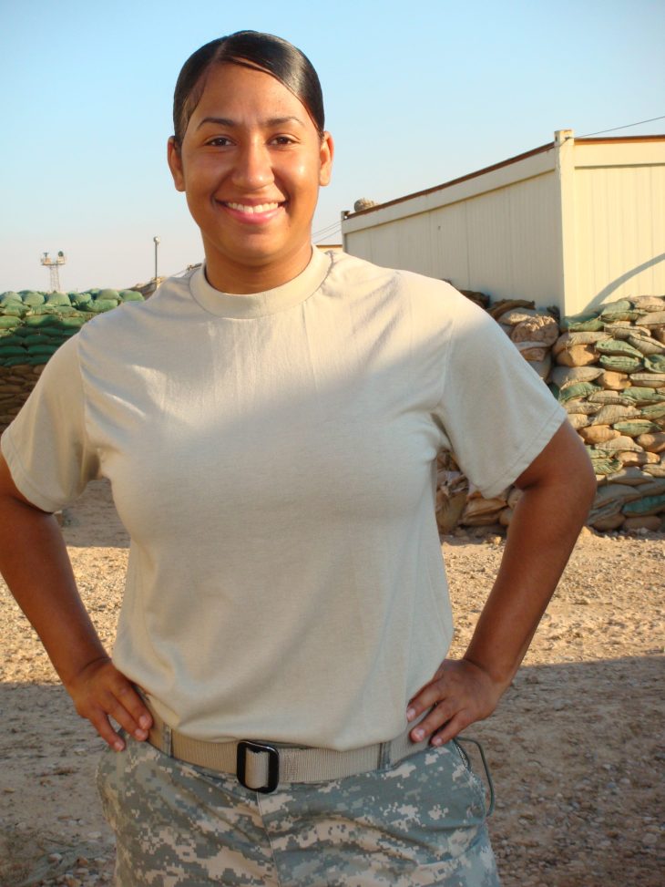 Woman standing with hands on her hips wearing military uniform.