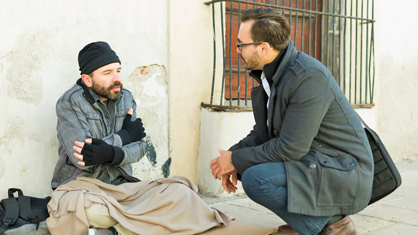 Man talking to homeless man.