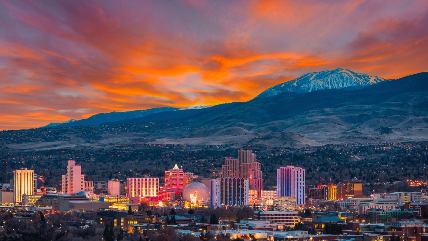 The skyline of Reno, Nevada with a mountain range backdrop.