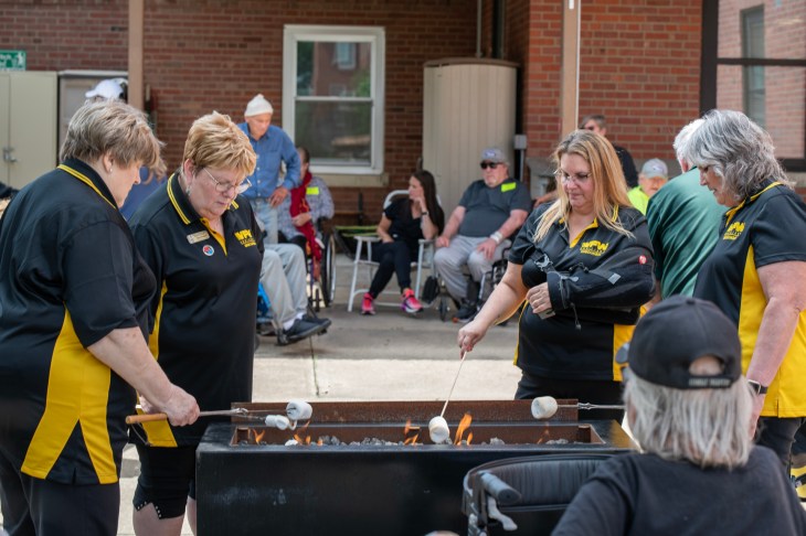Women roasting marshmallows during a VFW barbecue.