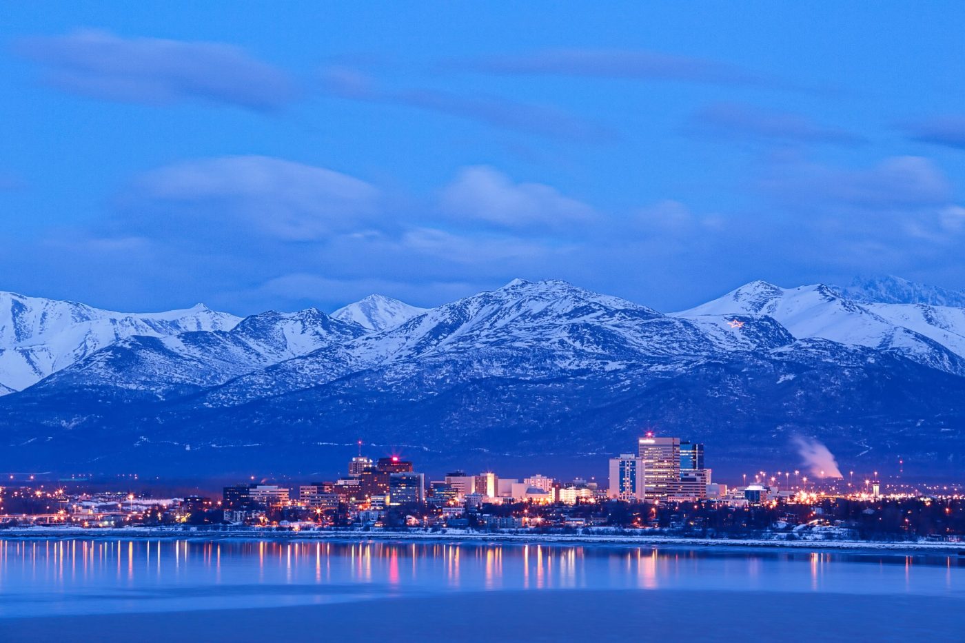 Alaska mountains with city view on water.