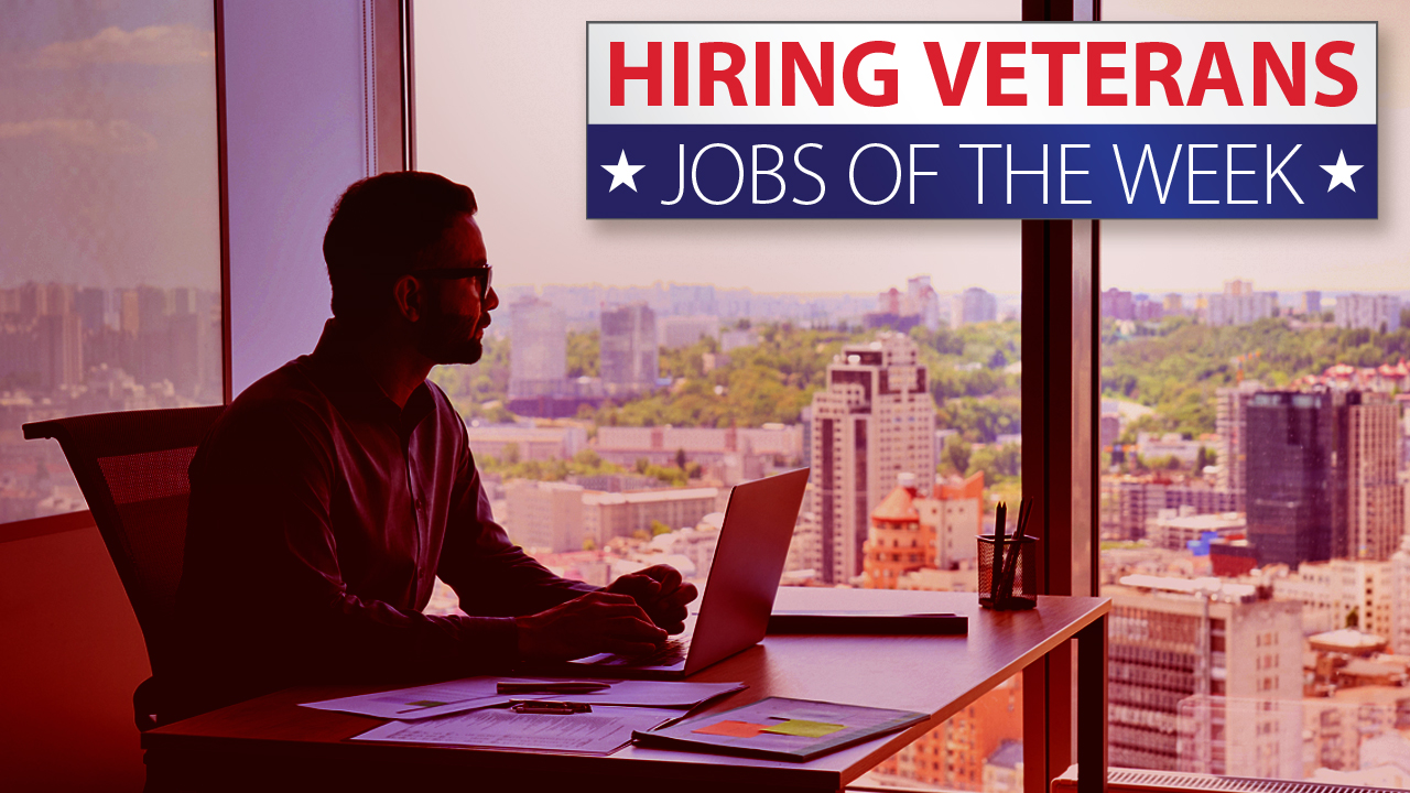 Hiring veterans. Man sitting in office building with a laptop looking out the window.