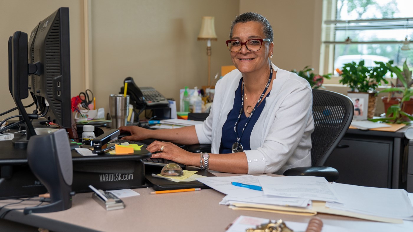 A VA administrator working at a desktop computer.